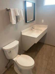 a bathroom with a white toilet and a sink at Sun Valley Inn in Pleasant Hill
