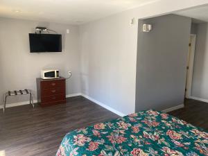 1 dormitorio con 1 cama y TV en la pared en Sun Valley Inn, en Pleasant Hill