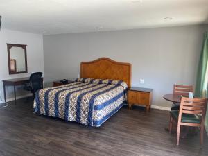 a bedroom with a bed and a table and a desk at Sun Valley Inn in Pleasant Hill