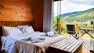 a bedroom with a bed and a large window at Cascata dos Amores in Urubici