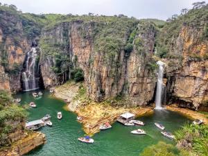 a group of boats in the water near a waterfall at Casa do Diogo in Capitólio