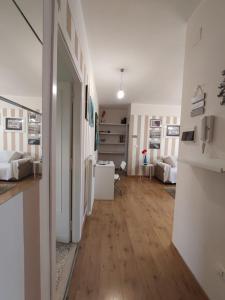 un soggiorno con pavimenti in legno e pareti bianche. di La Mansarda ad Ascoli Piceno