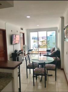 Una sala de estar con una mesa y sillas y un sofá. en Edificio Excalibur, en Santa Marta