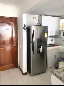 Una cocina con refrigerador de acero inoxidable en una habitación. en Edificio Excalibur, en Santa Marta