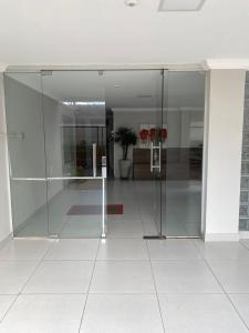 an open glass door in a building at Quarto em Apto ao lado Shopping in Cuiabá