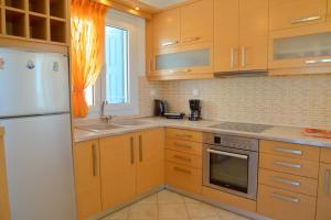 uma cozinha com armários de madeira e um frigorífico branco em Trypiti Sea View Apartment em Tripití