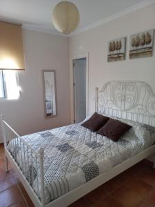 1 dormitorio con cama blanca y colcha blanca en Casa Rafael-Chalet con piscina privada en Chiclana de la Frontera