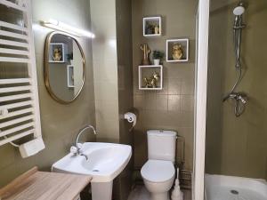 a bathroom with a toilet and a sink and a mirror at Studio 1 - 4 pers à 300m de la plage avec vue mer in Stella-Plage