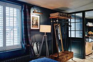 Habitación con paredes azules y lámpara de pie. en Kings Arms en Egham