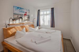 a white bed with white pillows on it at Ferienwohnung Kon-Tiki, Villa Regina Maris Bansin in Heringsdorf