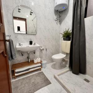 La salle de bains est pourvue d'un lavabo, de toilettes et d'un miroir. dans l'établissement F2 - Lovely two bedrooms Flat sea View, St Julians, à Tal-Għoqod