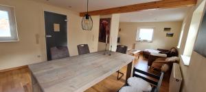 a living room with a wooden table and chairs at Eifelhof mit Obstbaumwiese in Nideggen