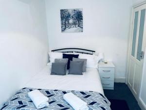 um quarto com uma cama com almofadas azuis e brancas em Cheerful Town House in Coventry City Centre em Coventry