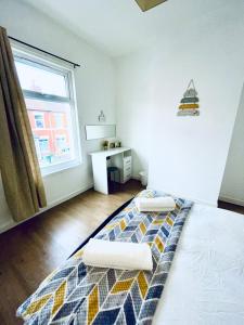 um quarto com uma cama com duas almofadas em Cheerful Town House in Coventry City Centre em Coventry