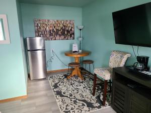 a living room with a refrigerator and a table at Viking INN Clara City in Clara City