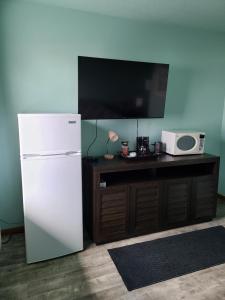 a white refrigerator next to a table with a microwave at Viking INN Clara City in Clara City