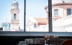 una ventana con vistas a una torre del reloj en Apto. entero Ciudad Vieja, en Montevideo