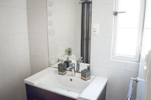 a white bathroom with a sink and a mirror at Apto. entero Ciudad Vieja in Montevideo +34 photos