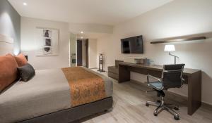 a hotel room with a bed and a desk and a chair at Real Inn Perinorte in Mexico City