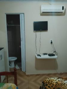 a room with a tv on the wall and a bed at Hostel Morais in Maceió