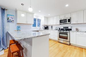 a kitchen with white cabinets and a marble counter top at Collingwood Cottage in Yarmouth Port