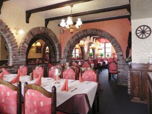 a restaurant with red chairs and tables in a room at Hotel - Restaurant Braustube in Haaren
