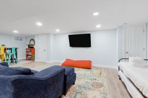 a living room with a couch and a tv on a wall at Collingwood Cottage in Yarmouth Port