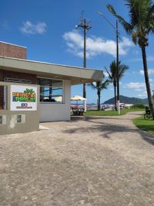 a building with a palm tree in front of it at VARANDA GOURMET c churrasqueira-3 quartos- Wi-fi in Bertioga