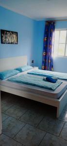 蒂哈拉費的住宿－Finca Marita，卧室内的一张床铺,卧室内有蓝色的墙壁