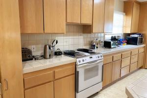 a kitchen with wooden cabinets and a white stove top oven at Spacious family oasis in silicon beach 5mins to LAX in Los Angeles