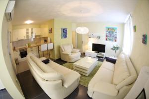 ein Wohnzimmer mit 2 weißen Sofas und einem TV in der Unterkunft Apartment Zubčić in Zadar