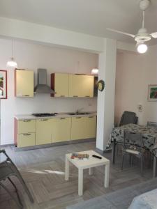 a living room with a kitchen and a table at casa delle rose in Isola delle Femmine +15 photos