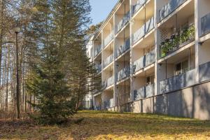 an apartment building with a tree in front of it at Apartament Jelonek Zdrój in Polanica-Zdrój