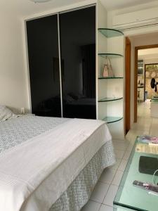 a bedroom with a white bed and a glass shelf at Monte Castelo Gravatá in Gravatá +47 photos