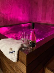 ツベレツにあるApartmány Roháčeのバスタブにワイン1本とグラス2杯