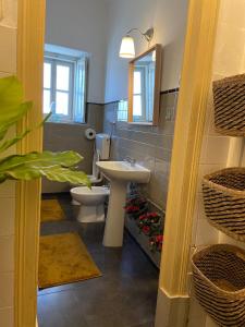 W łazience znajduje się umywalka, toaleta i lustro. w obiekcie casa da vila w mieście Mora