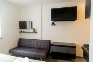 a living room with a couch and a flat screen tv at Ipanema 309 Studio in Rio de Janeiro