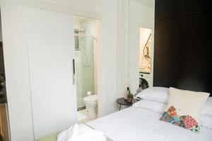 a bedroom with a white bed and a bathroom at Ipanema 309 Studio in Rio de Janeiro