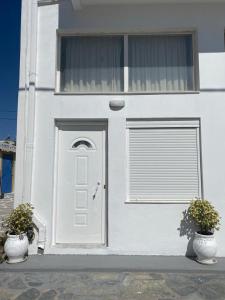 Biały dom z drzwiami i oknem w obiekcie Studio by the sea w Kardamenie