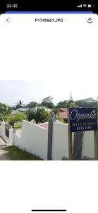a sign in front of a white fence at Ogumka, Self catering , Beoliere, Mahe in Victoria