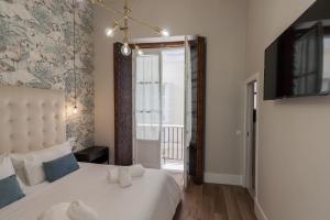 a bedroom with a white bed and a window at Casa Mariana - Luxury Apartment - 4 Personas in Cádiz