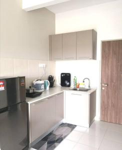 a kitchen with white cabinets and a stainless steel refrigerator at NiDaHomeStay Nilai USIM KLIA WiFi androidtv full aircond in Nilai