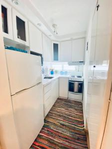 eine Küche mit weißen Schränken und einem Kühlschrank in der Unterkunft KASA Ocean Breeze - Cabana Studio Apartment BEACHFRONT CONDO POOL in San Juan