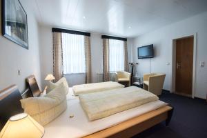 um quarto de hotel com duas camas e uma televisão em Zellerfelder Hof em Clausthal-Zellerfeld