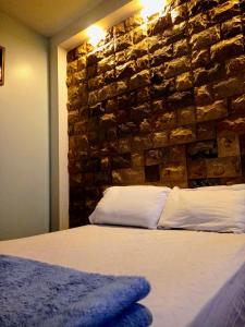 a bed in a room with a stone wall at Casa Scalesia in Puerto Baquerizo Moreno