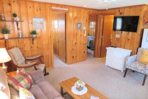 a living room with a couch and a tv at 2 Minute Walk to Beach, Cape Cod Escape in Dennis Port