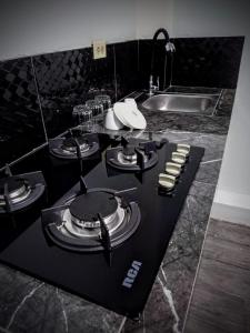 a black counter with plates and dishes on it in a kitchen at Casa Scalesia in Puerto Baquerizo Moreno