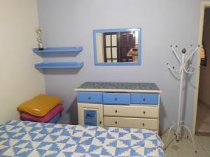 a bedroom with a bed and a dresser and a mirror at Casa temporada Peró Cabo Frio in Cabo Frio