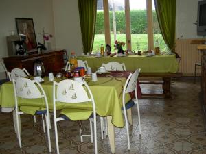 un comedor con mesas verdes y sillas en Le Bon Accueil, en Antrain