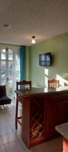 a kitchen with a table with two chairs and a tv on the wall at Beach Studio 9 in Ocho Rios